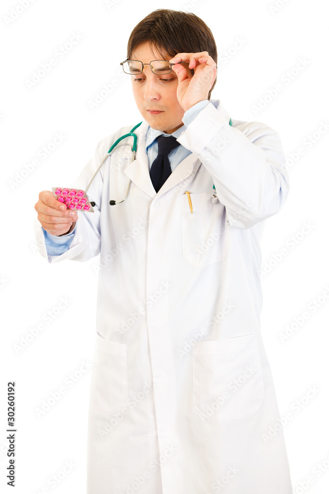 Doctor raising eyeglasses and reading name of drug Doctor raising eyeglasses and reading name of drug
