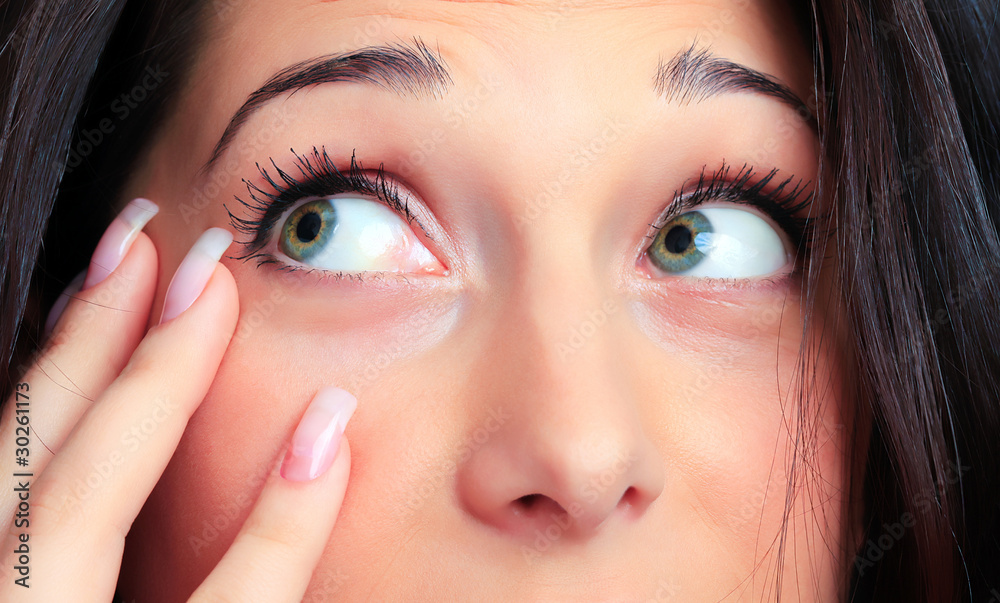 Fototapeta premium Closeup portrait of a pretty young woman touching her face