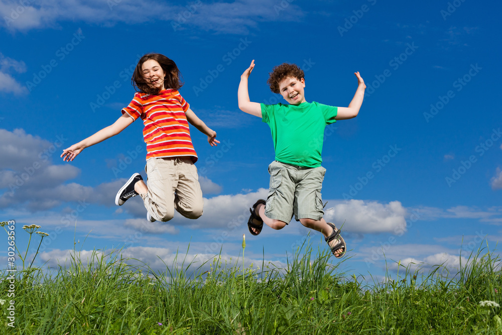 Girl and boy jumping, running against blue sky Girl and boy jumping, running against blue sky