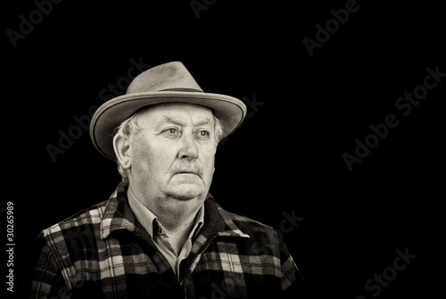 senior male retired wearing a hat on black