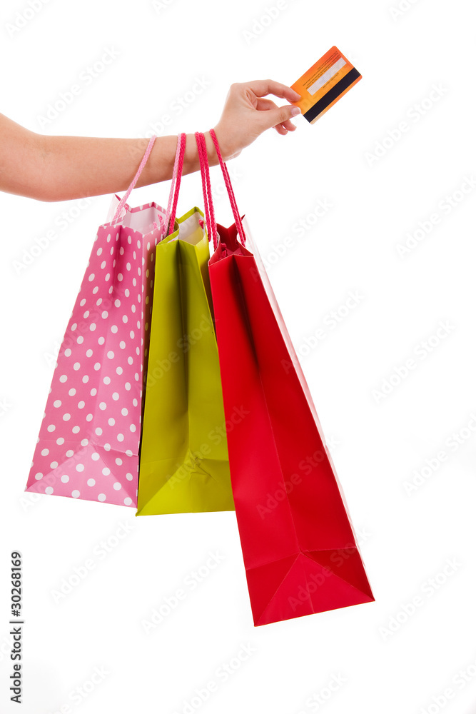 Female hand holding colorful shopping bags and a credit card