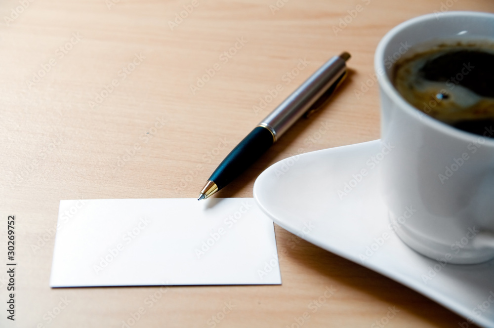 Blank card in a workplace and a cup of coffe Blank card in a workplace and a cup of coffe