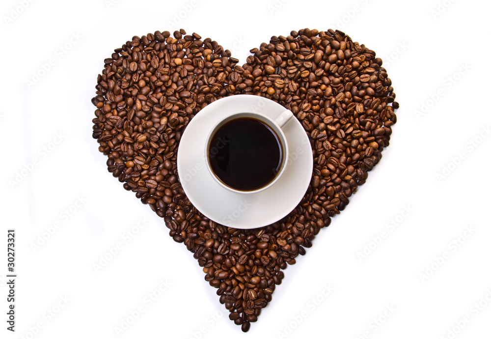 White cup of coffee on heart shaped coffee beans White cup of coffee on heart shaped coffee beans