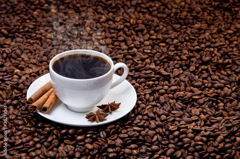 White cup of hot coffee on coffee beans White cup of hot coffee on coffee beans
