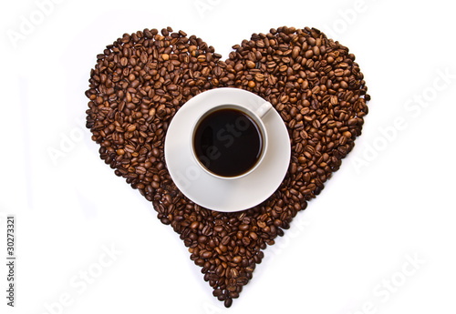 White cup of coffee on heart shaped coffee beans