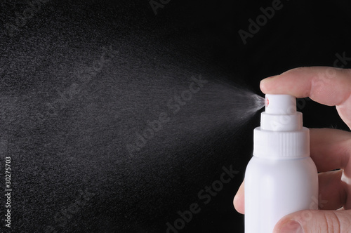closeup view of human hand spraying liquid in the empty space