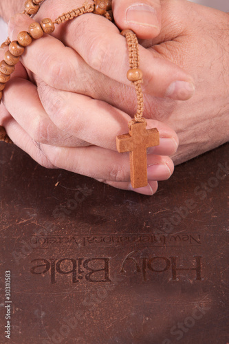 Person holding cross on bible photo