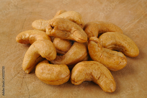 pile cashew nuts on wood background