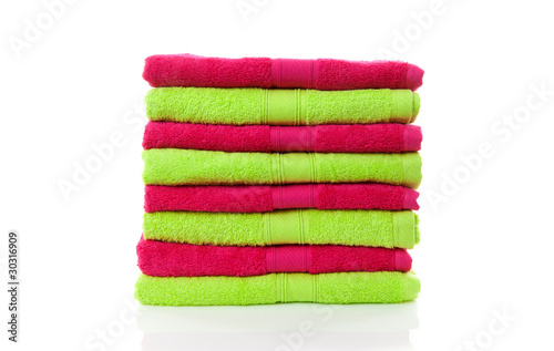 pile of lime green and pink towels over white background