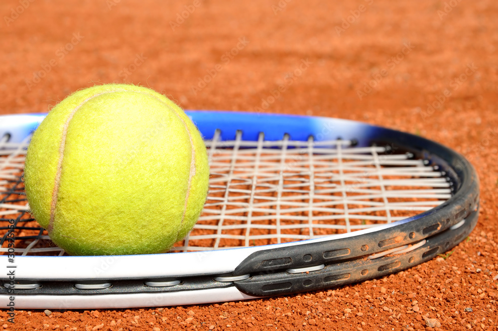 Tennis ball and racket on the court