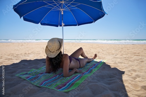 woman lie down under parasol
