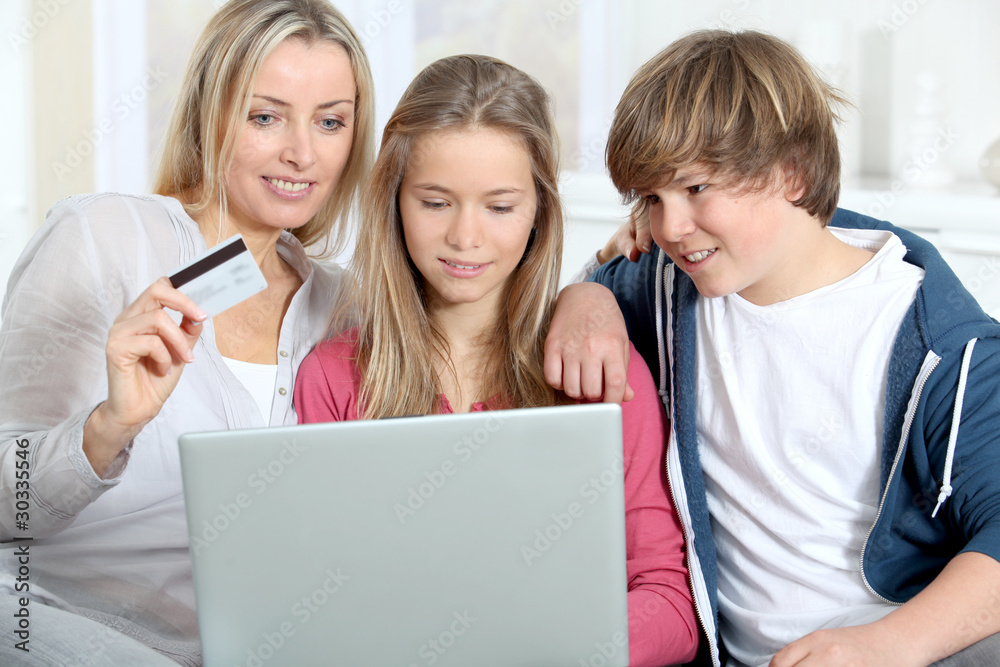 Mother and children at home doing online shopping Mother and children at home doing online shopping
