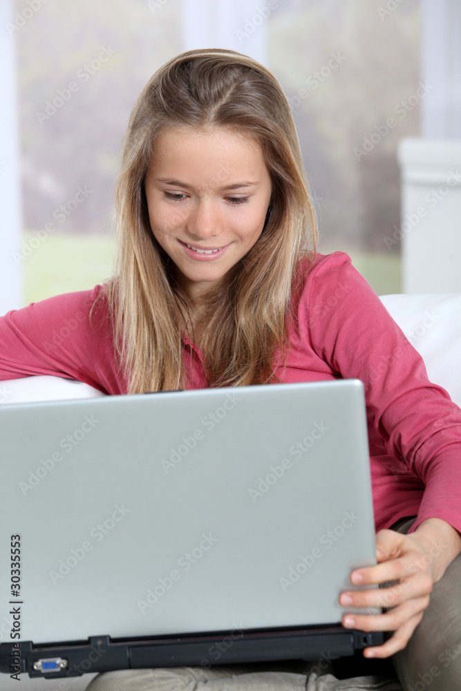 Blond teenager connected on internet at home Blond teenager connected on internet at home