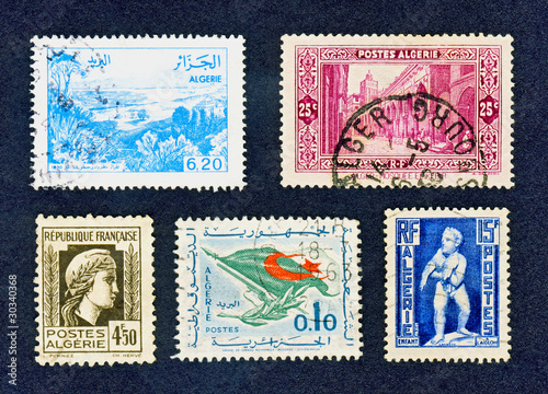 Close up of old cancelled Algerian stamps on black