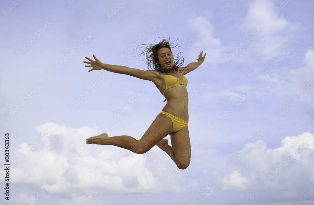 pretty girl in bikini jumping at a hawaii beach pretty girl in bikini jumping at a hawaii beach