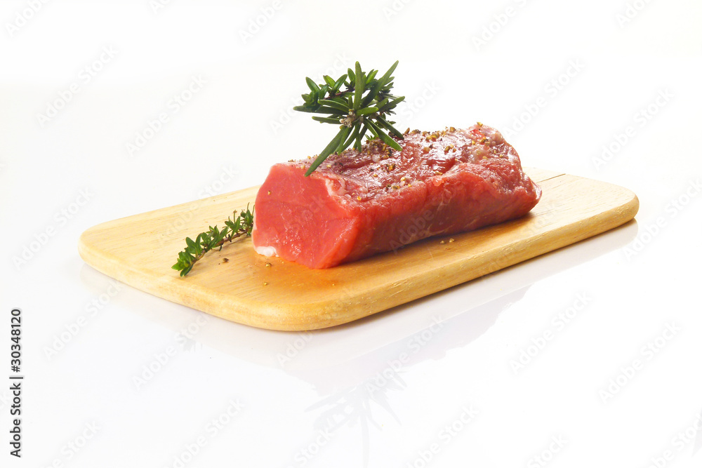 rohes Schweinefilet mit Kräutern auf Holzbrett / raw pork with h