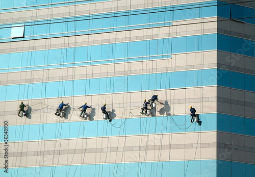 Workers clean the facade of the building.