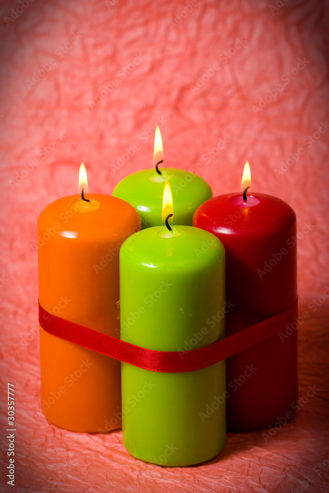 Christmas candles against a tinsel and red sphere