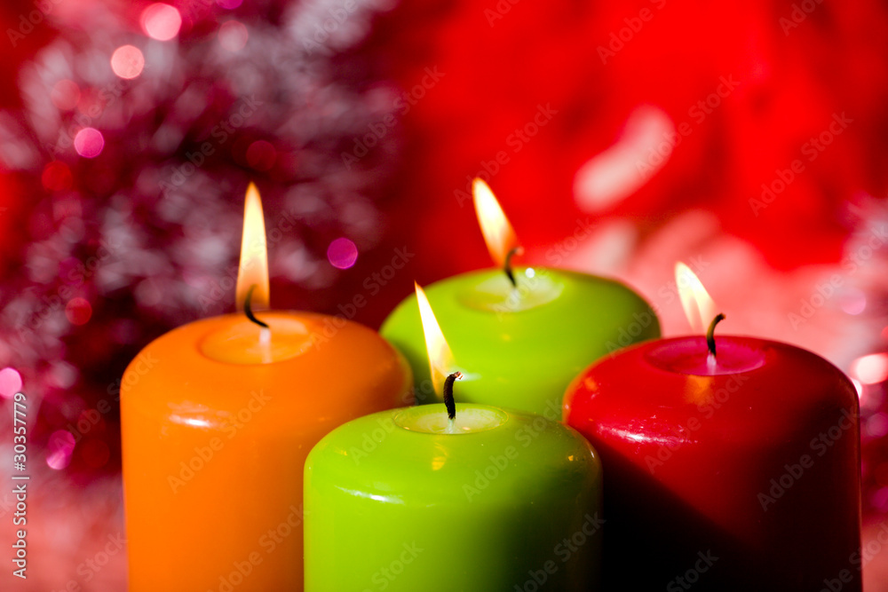 Christmas candles against a tinsel and red sphere Christmas candles against a tinsel and red sphere