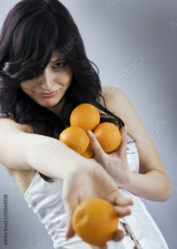 Pretty young girl offering an orange photo