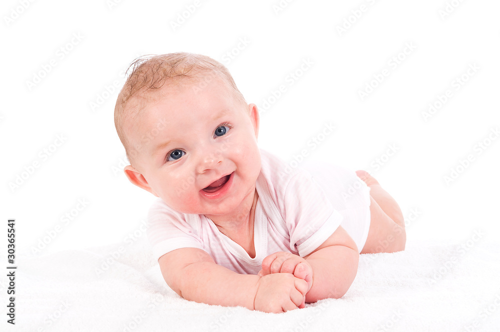 Baby liegt auf einer Decke und lächelt Baby liegt auf einer Decke und lächelt