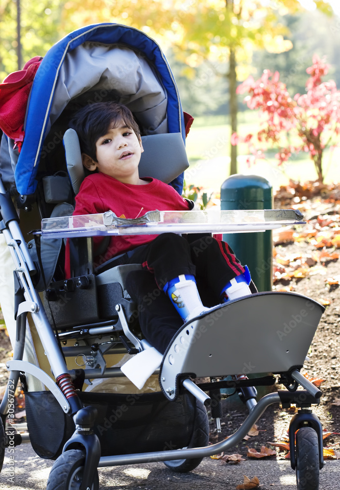 Disabled boy with cerebral palsy in medical stroller at park Photos Adobe Stock