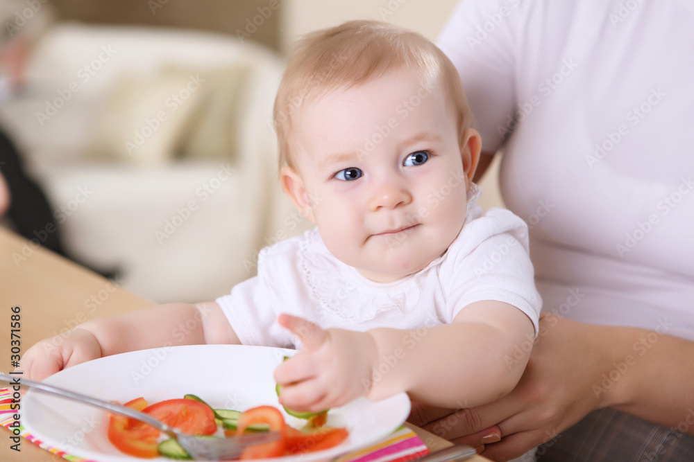 a young mother feeding her baby at home a young mother feeding her baby at home