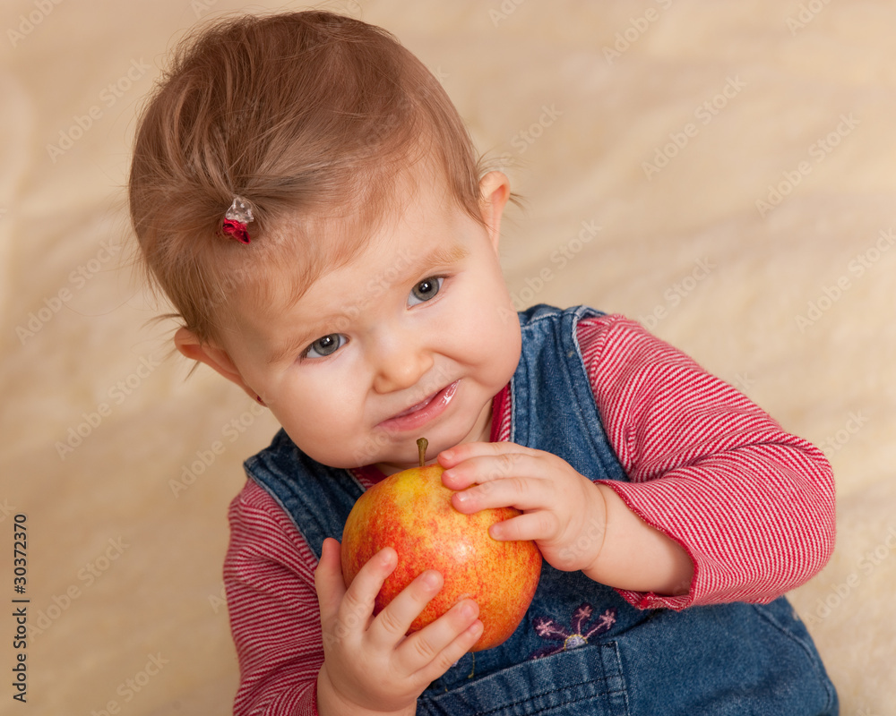 Toddler in casual eating a big red apple Toddler in casual eating a big red apple