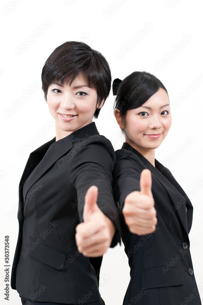 a portrait of two businesswomen showing thumb up a portrait of two businesswomen showing thumb up