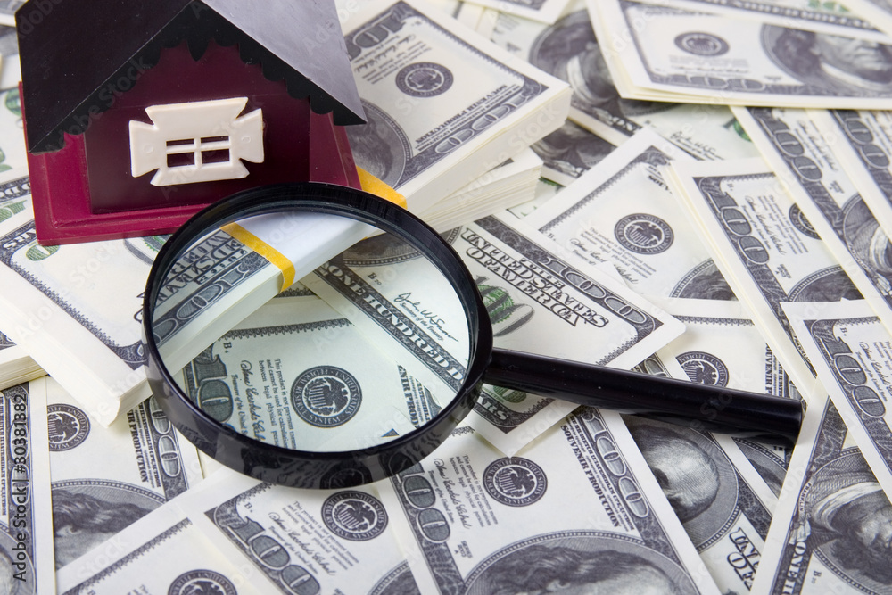 House and magnifying glass of one hundred dollar bills House and magnifying glass of one hundred dollar bills