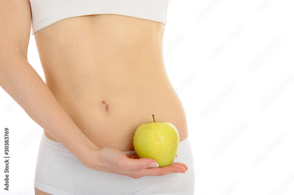 woman with beautiful body holding an apple near the slim waist. woman with beautiful body holding an apple near the slim waist.
