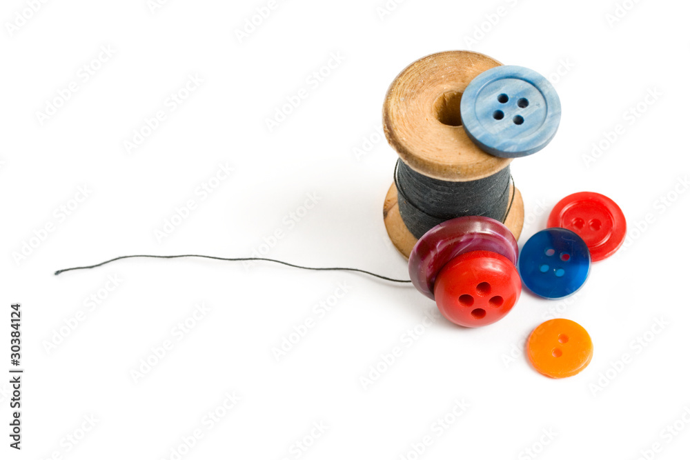 Thread bobbin and buttons isolated on white background Thread bobbin and buttons isolated on white background