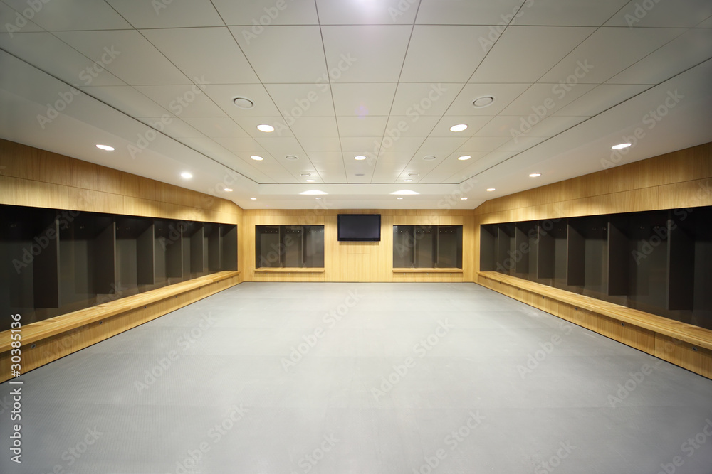large clean locker room. gray floor and ceiling, big televisor