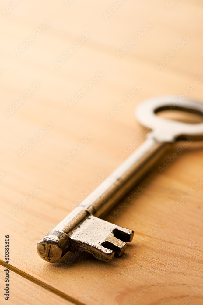 Key isolated on wooden background Key isolated on wooden background