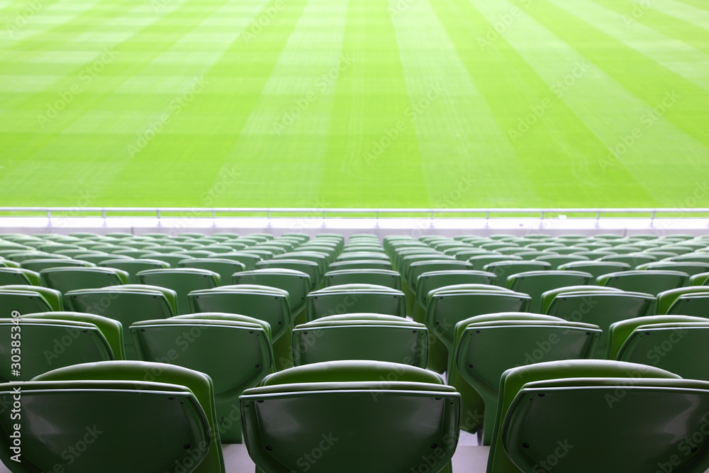Obraz premium Rows of folded, green, plastic seats in very big, empty stadium