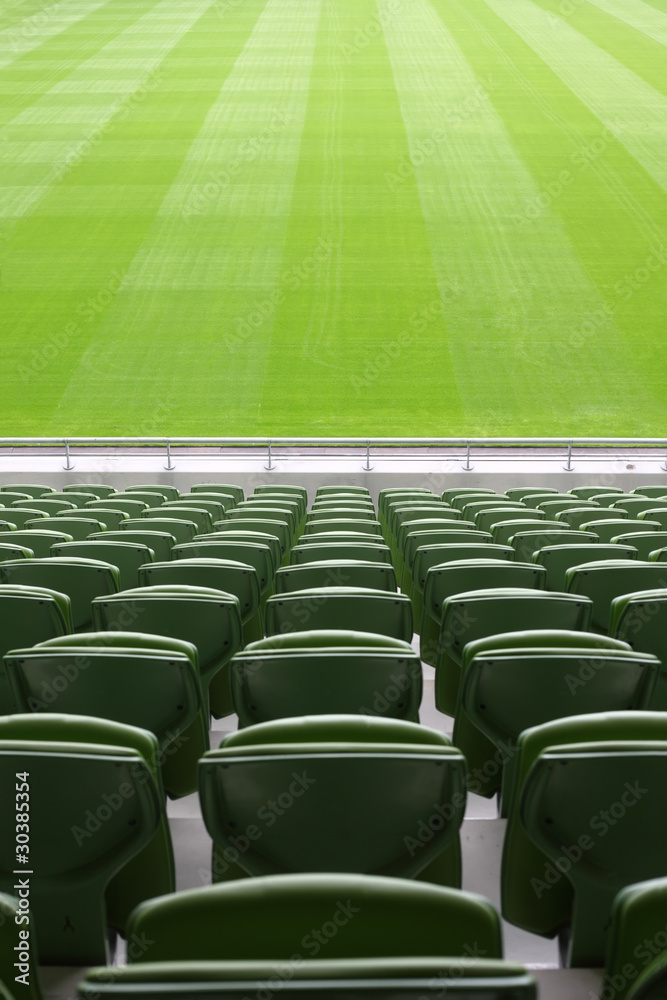 Fototapeta premium Rows of folded, green, plastic seats in very big, empty stadium
