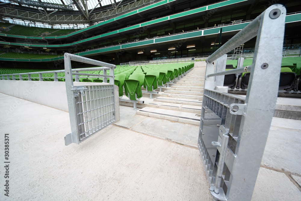 Fototapeta premium Rows of folded, green, plastic seats in very big, empty stadium,