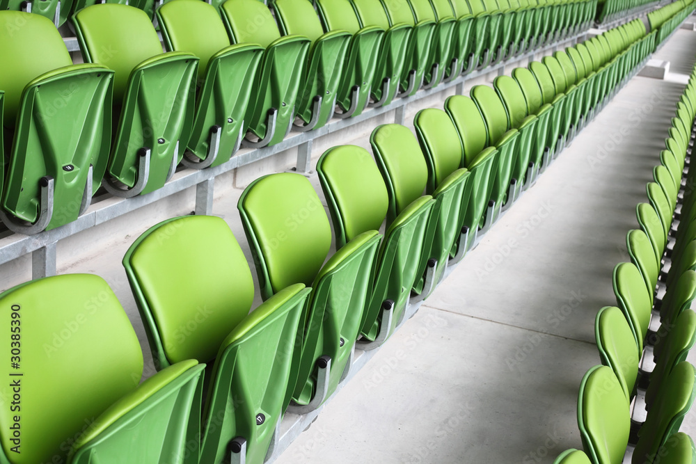 Naklejka premium Rows of folded, green, plastic seats in very big, empty stadium