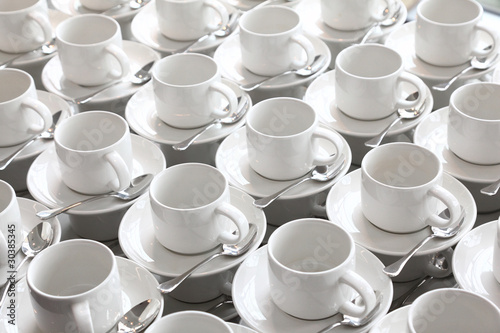 many rows of pure white cup and saucer with teaspoon photo