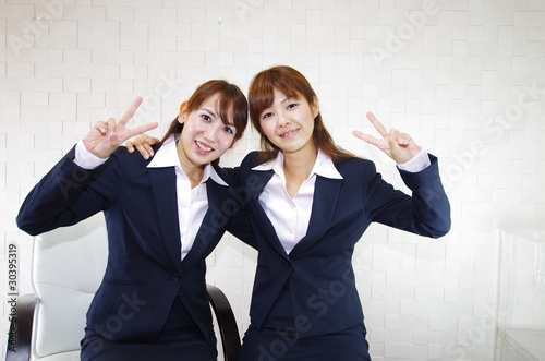 ピースサインをしている笑顔の二人のオフィスレディー Stock Photo Adobe Stock