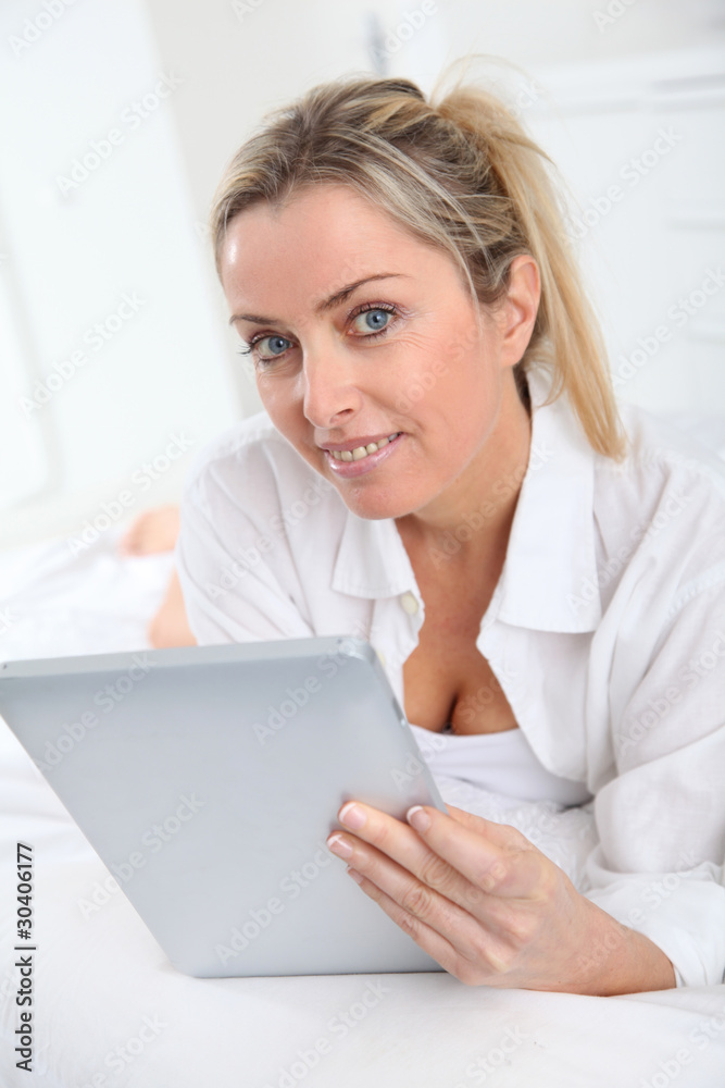 Blond woman using electronic tablet at home Blond woman using electronic tablet at home