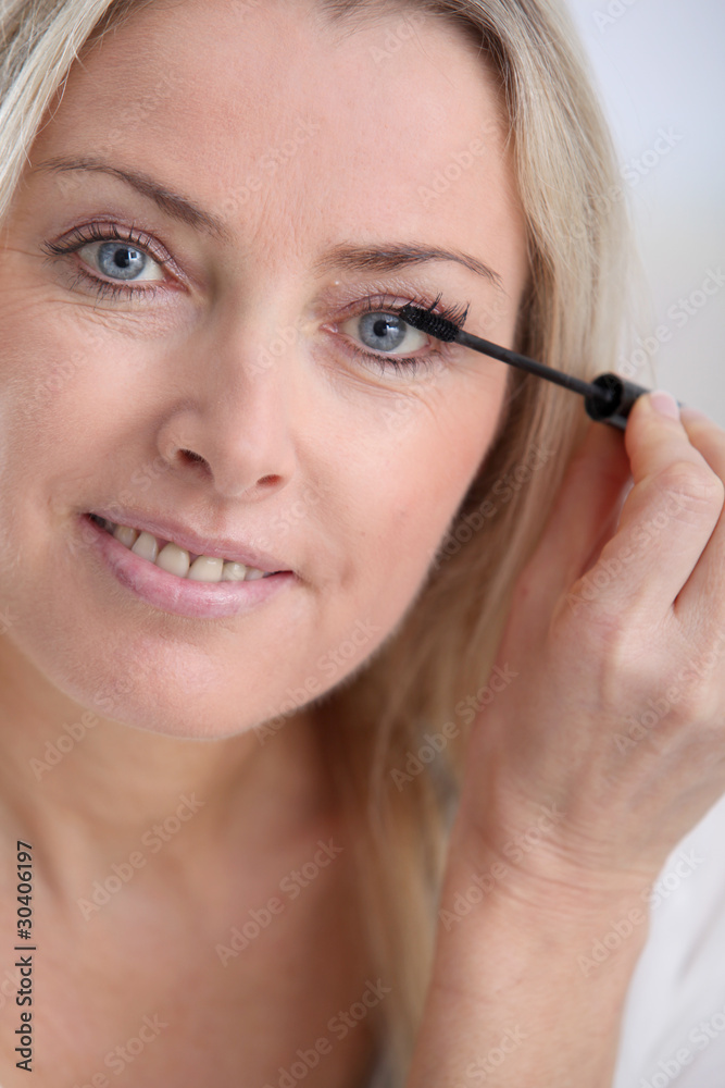 Closeup of woman applying mascara on eyelashes Closeup of woman applying mascara on eyelashes