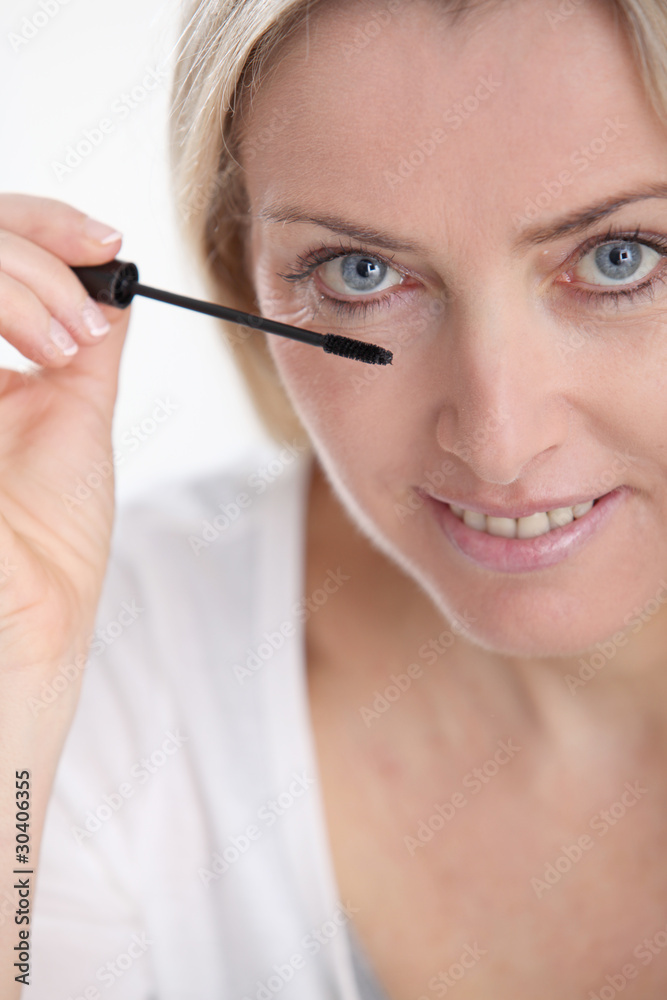 Closeup of woman applying mascara on eyelashes Closeup of woman applying mascara on eyelashes