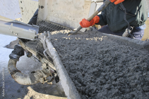 Fotografía Construction worker pouring cement into pump