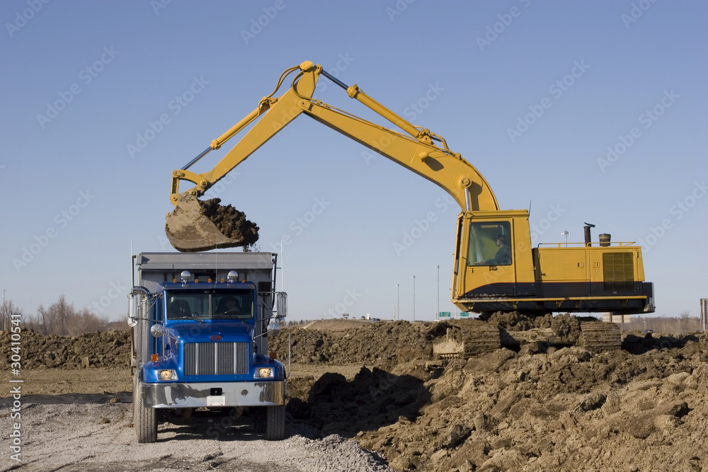 Excavator and dumptruck on construction site