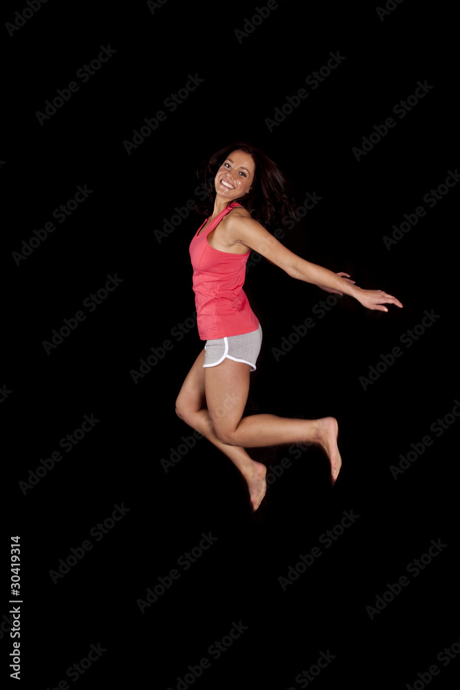 Woman jumping black background