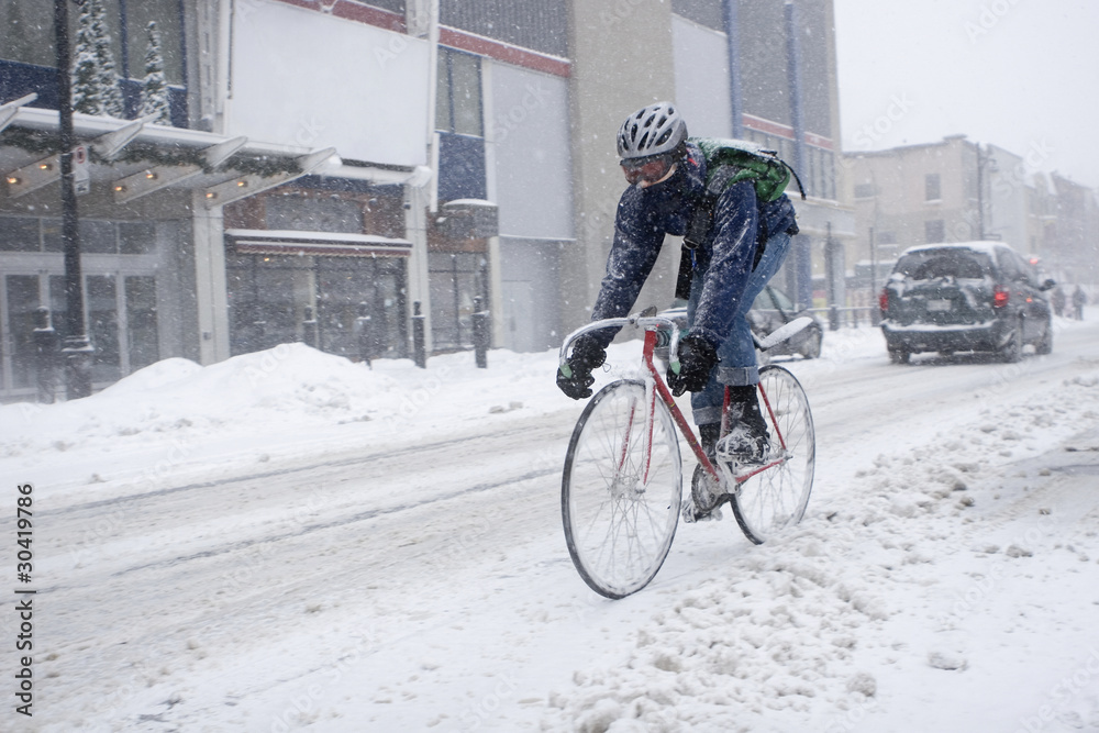Fototapeta premium Bicycle courier in winter snow storm