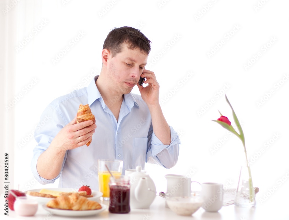 man speaking on the phone while having breakfast man speaking on the phone while having breakfast