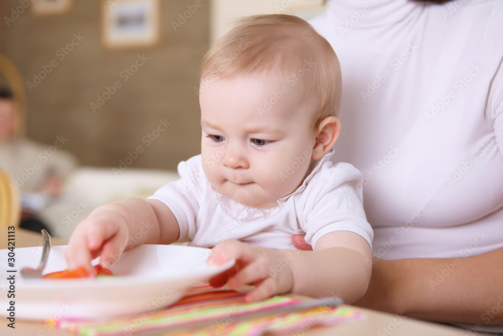 a young mother feeding her infant baby at home a young mother feeding her infant baby at home
