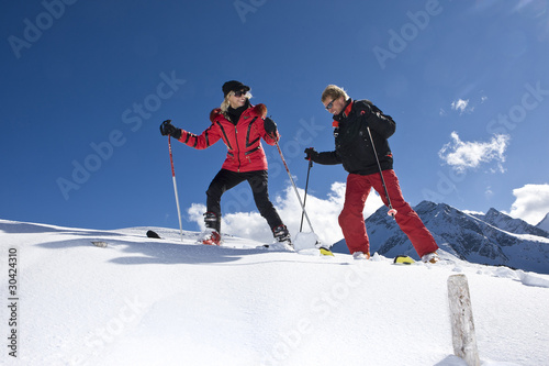 Zwei Skifahrer steigen Schneehang hoch